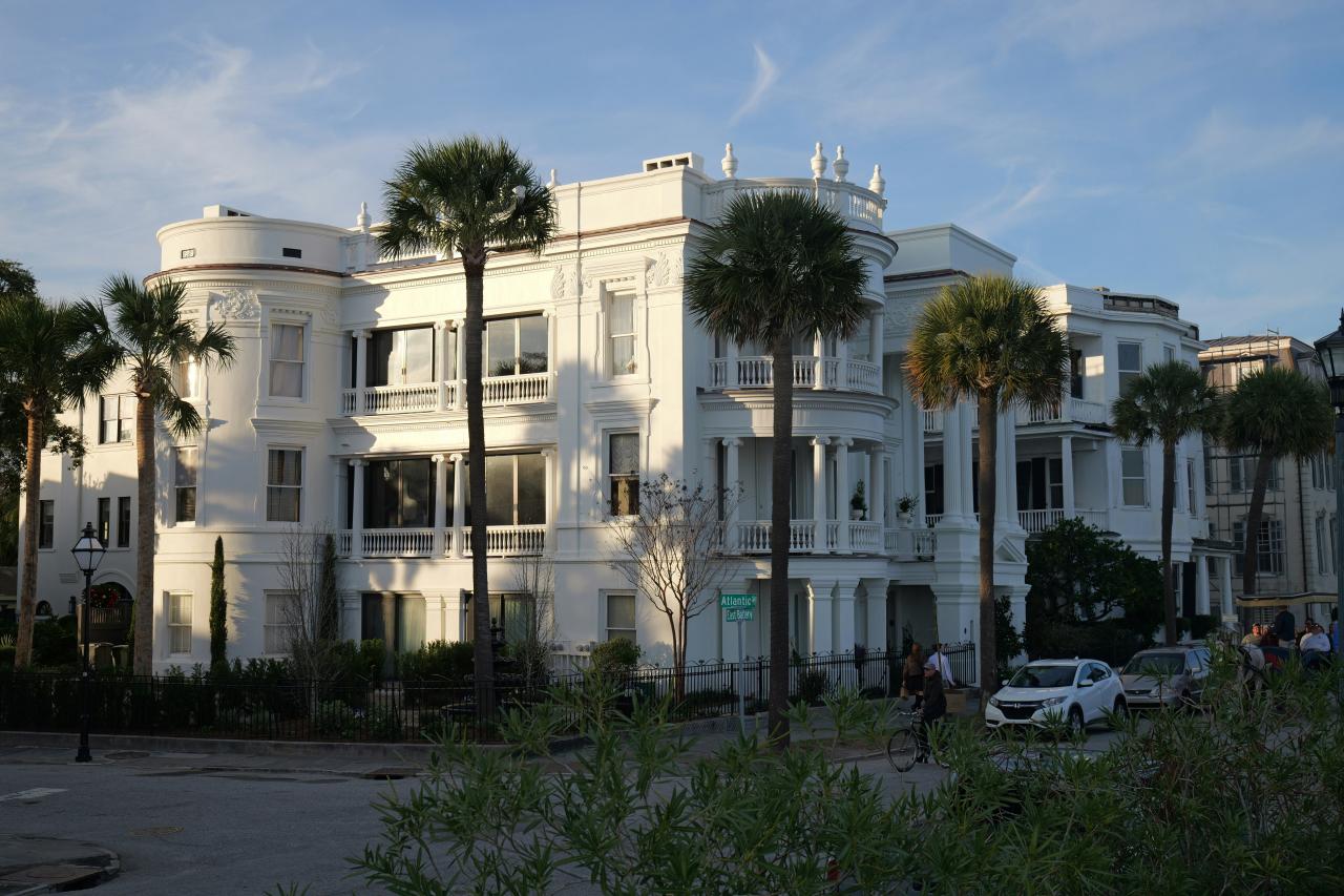 A large white building with palm trees in front of it